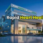 Modern exterior of Aster Hospital Mankhool in Dubai at twilight with a glowing medical shield representing rapid healthcare.